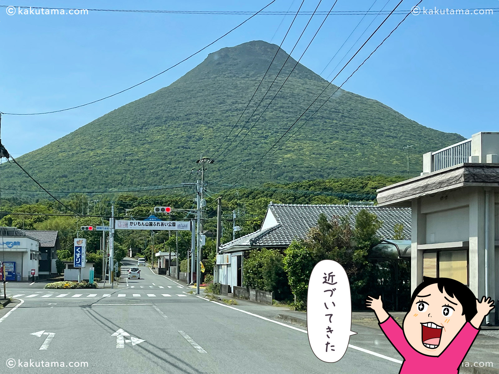 開聞岳へ向かって走る車から見た開聞岳の写真と登山者のイラスト