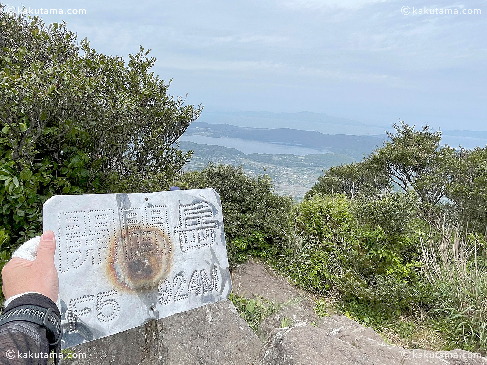 開聞岳の金属看板を持って記念撮影