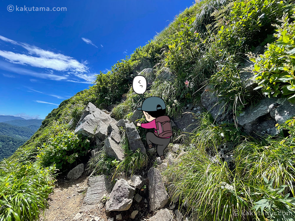 雨飾山山頂直下の岩場の写真と登山者のイラスト