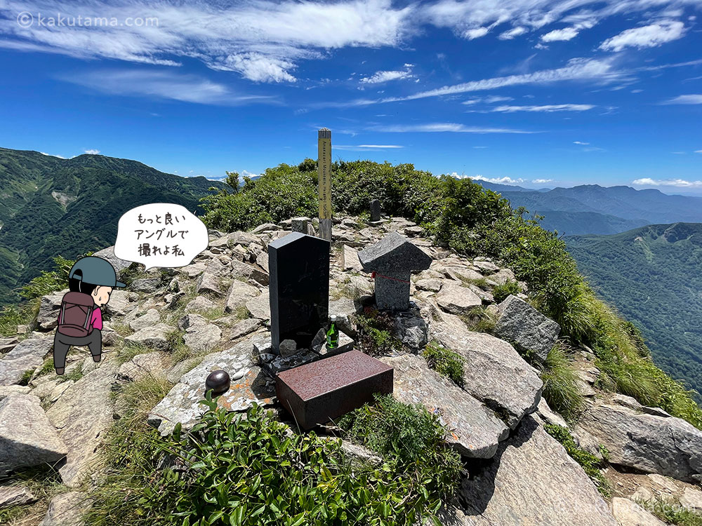 雨飾山南峰の山頂の写真と登山者のイラスト